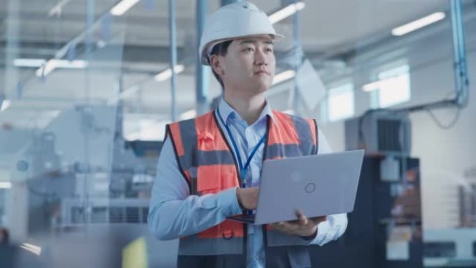 一位穿着橙色安全背心的亚洲男性工程师在电子制造工厂的笔记本电脑上工作的肖像。处理日常任务和研发数据的