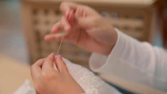 年轻的亚洲女性正在学习在线练习缝纫。