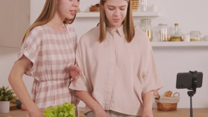开朗的双胞胎姐妹在厨房录制烹饪视频