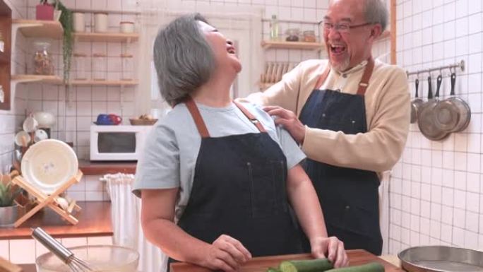 老年夫妇在厨房做饭时愉快地聊天。它代表了他们俩持久的爱。退休时的幸福