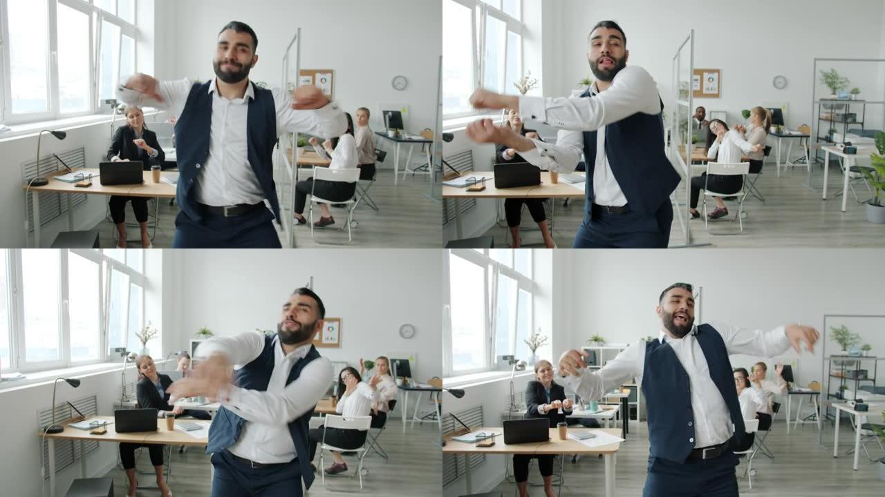 有吸引力的商人在办公室里跳舞移动身体的慢动作肖像看着相机