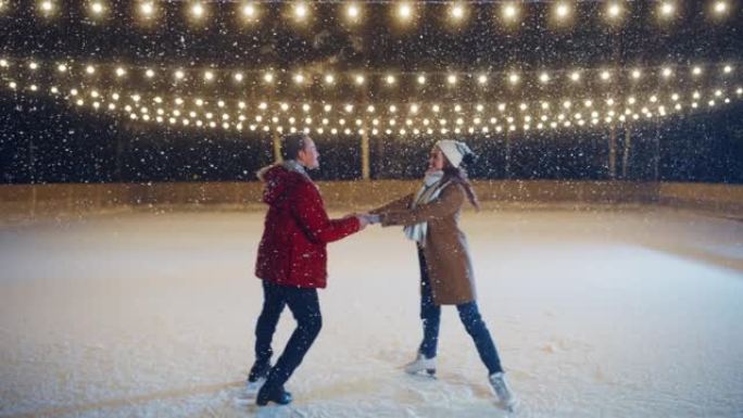 浪漫的冬天下雪的夜晚: 滑冰夫妇在溜冰场上玩得开心。双人花样滑冰男孩和女友在恋爱，跳舞，旋转，拥抱中