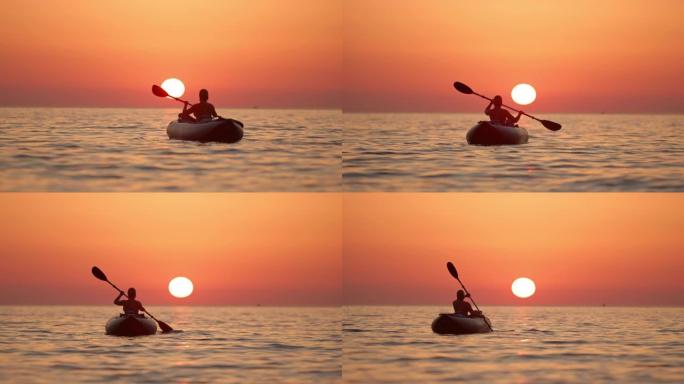克罗地亚亚得里亚海日落时，WS剪影年轻女子在宁静的海洋上划桨船