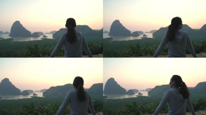 亚洲体育女子站在山顶，在日落时欣赏壮丽的景色