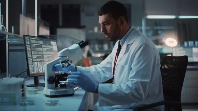 医学研究科学家在显微镜下进行DNA实验，并在生物科学实验室的台式计算机上写下结果。穿着白大褂的白人实