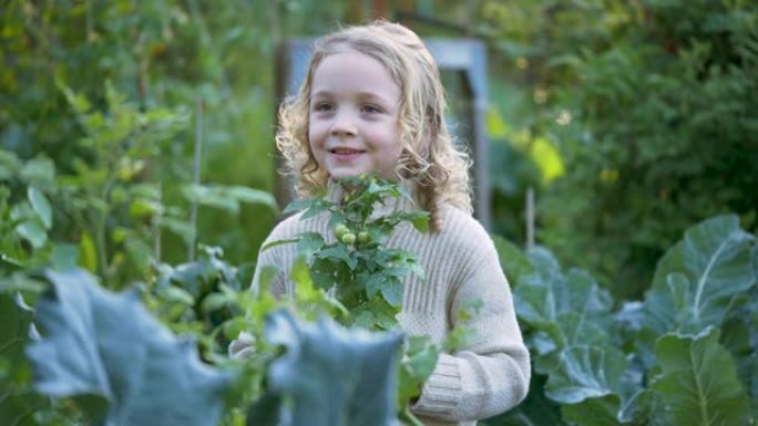 小女孩在社区花园里拿着盆栽