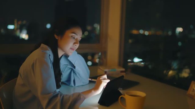 女人晚上使用数字平板电脑在办公室工作