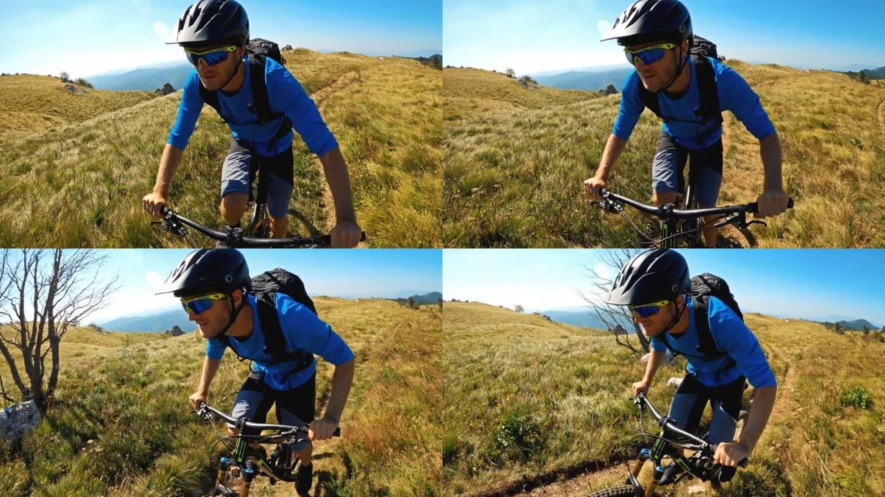 晴天在山上的岩石草地小径上骑自行车
