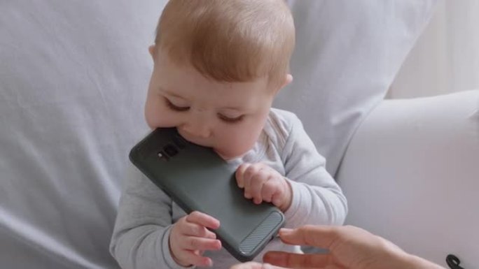 有趣的婴儿与智能手机幼儿一起玩，对在家中使用移动技术学习的婴儿感到好奇