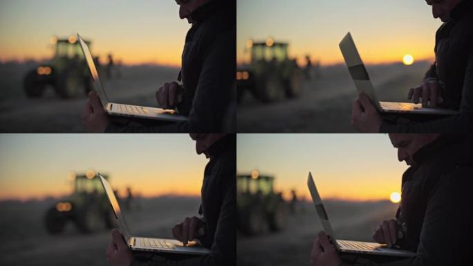 男性农民在日出时在农村使用笔记本电脑