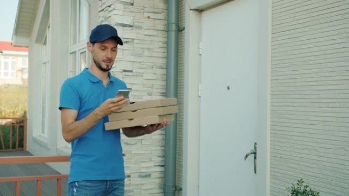 送货员在手机上聊天，然后给站在外面的顾客提供装有食物的盒子