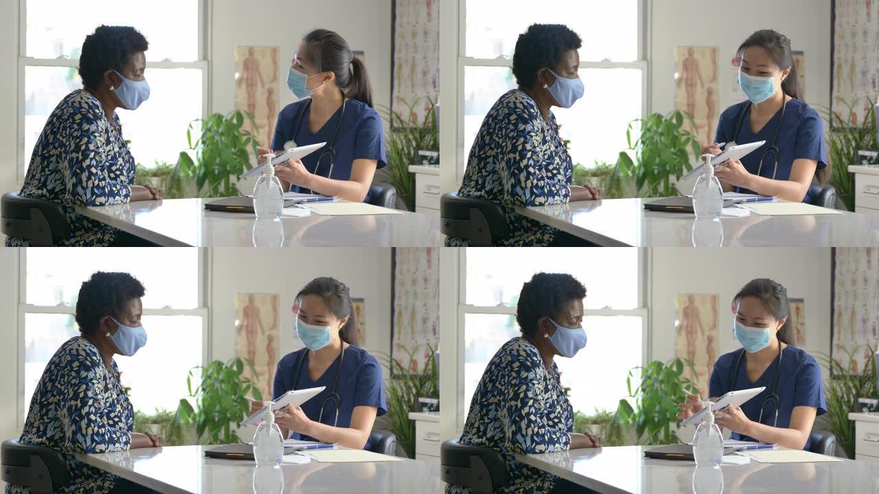 女医生与年长病人在门诊预约时戴口罩