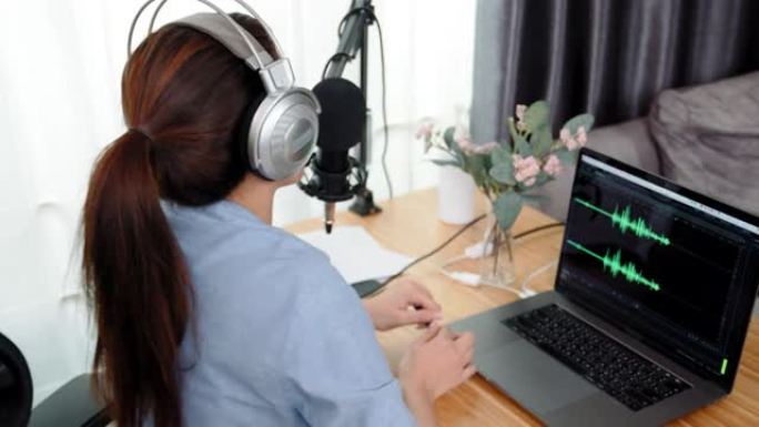 女人播客录音和编辑手提电脑上的声波设计
