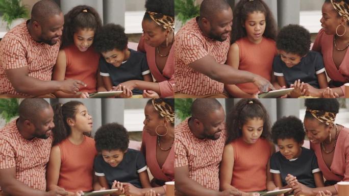 非洲四口之家在数字平板电脑上玩游戏