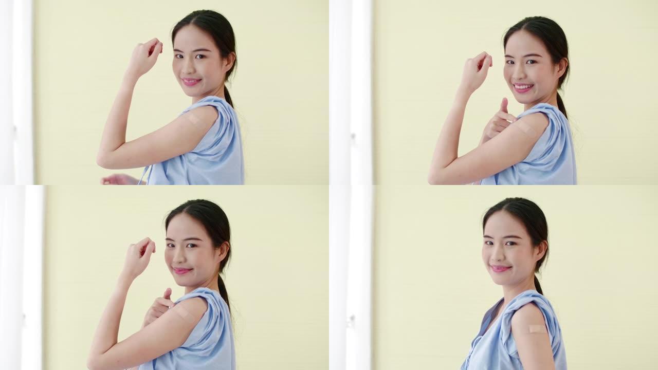年轻的亚洲妇女在隔离背景下接种疫苗后露出手臂