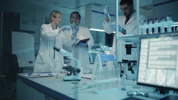 医学研究科学家团队在试管和平板电脑中的DNA样本的帮助下开会并进行实验。应用科学实验室，拥有多元多元