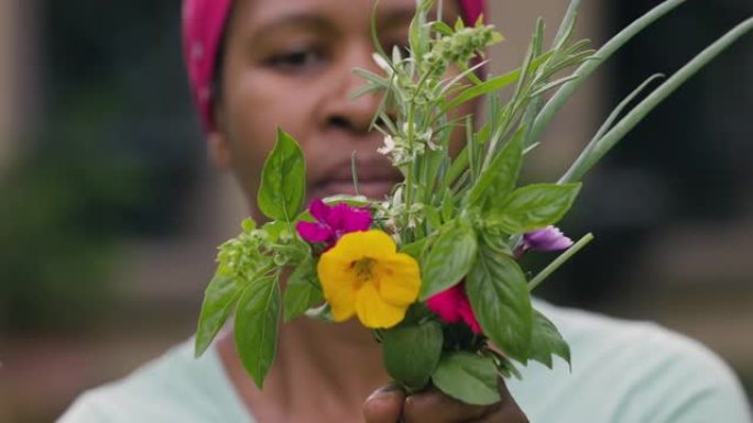 Close-up.Black的非洲妇女拿着一束新鲜健康的草药和可食用的花