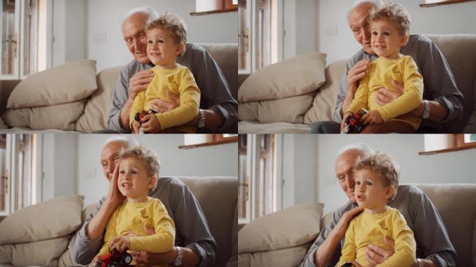孩子和祖父之间的美好时光: 老人看电视并与孙子交谈。这个可爱的小男孩正在与他的祖父分享和解释他最喜欢