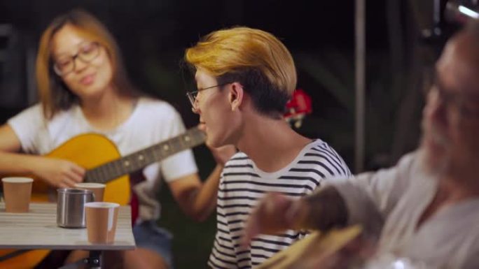 亚洲中国十几岁的男孩喜欢和父亲和妹妹一起唱歌，晚上玩吉他ingarden派对露营帐篷