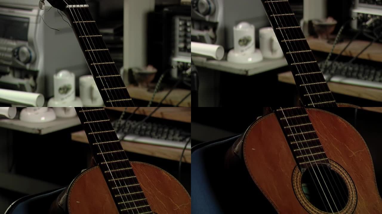 一把用过的西班牙旧吉他支撑在房间的椅子上。特写。