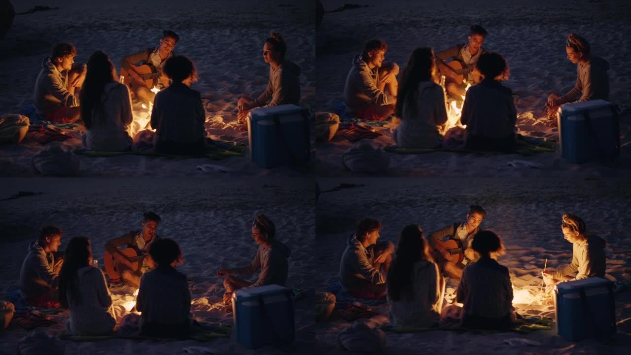 4k视频片段，一群不同的朋友围坐在火炉旁，日落时在海滩上结伴