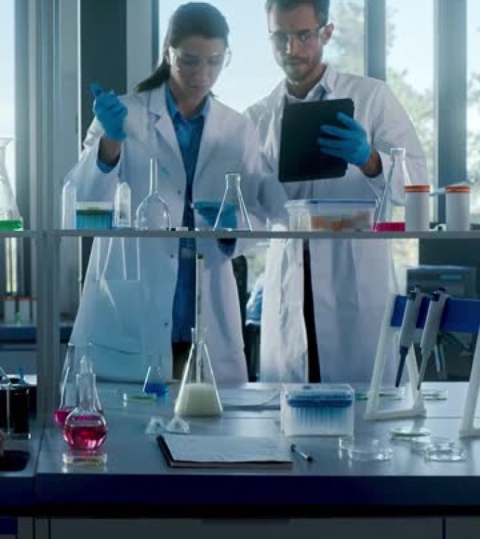 医学实验室与不同团队的生物化学研究科学家交谈，两名微生物学家使用平板电脑，微量移液器。开发药物，基因