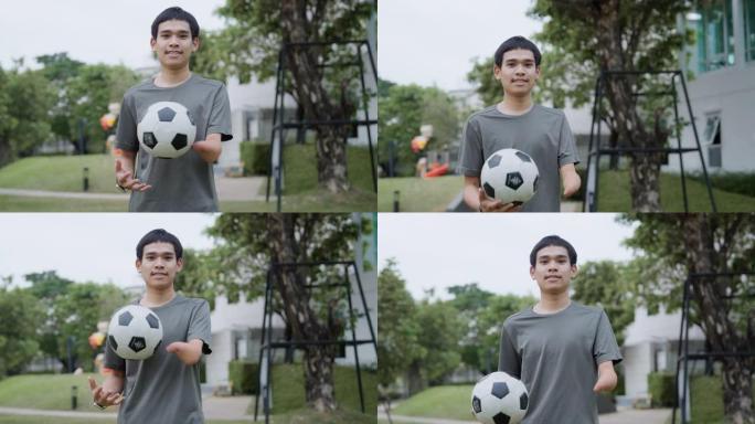 一个手臂残疾的快乐年轻人拿着足球的肖像。