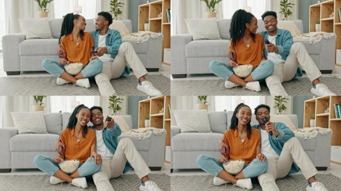 幸福的黑人夫妇，在他们家或房子的客厅里吃爆米花和看电影。爱情，浪漫和男人和女人在看电视和浏览频道时有