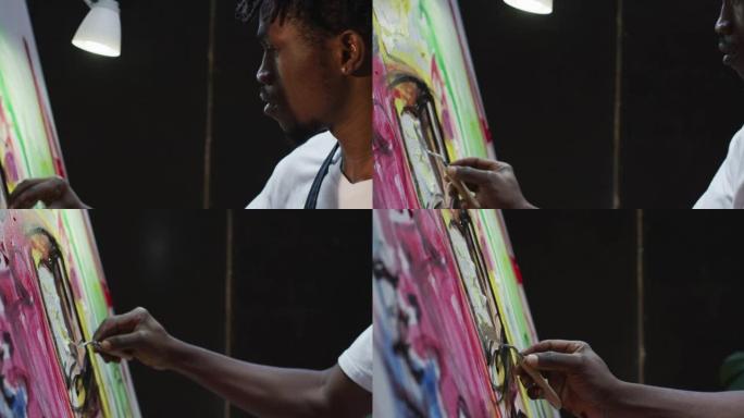 在艺术工作室用调色板刀在画布上的非裔美国男艺术家绘画特写