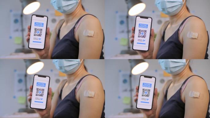 戴着医用口罩的女人从智能手机屏幕上显示数字疫苗护照