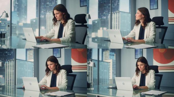 年轻成功的白人女商人坐在办公桌前在城市办公室的笔记本电脑上工作的肖像。雄心勃勃的公司经理计划电子商务