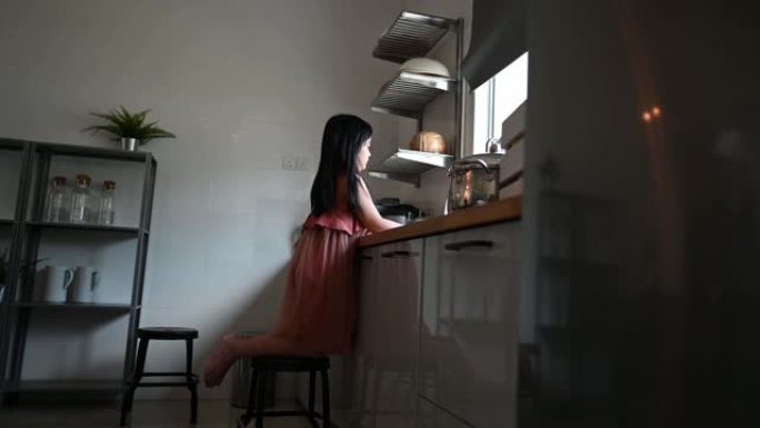 亚洲中国小女儿在厨房里洗碗