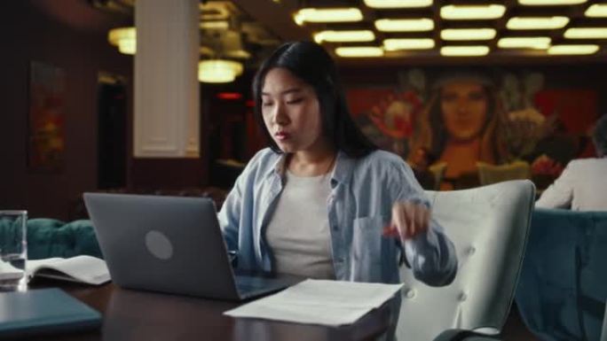 在餐厅使用笔记本电脑的女商人