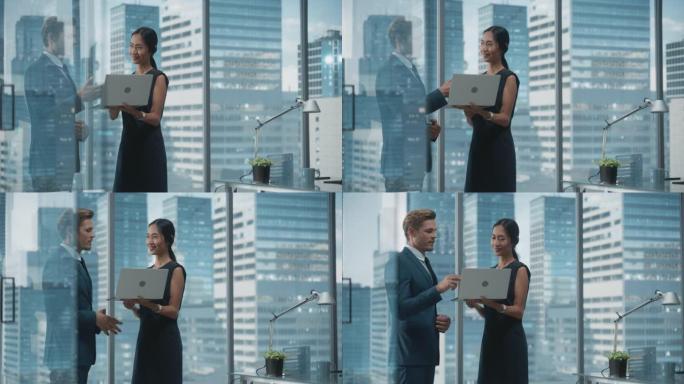 成功的公司首席执行官和投资经理的肖像，站在城市办公室时使用笔记本电脑交谈。两个成功的商人就电子商务营