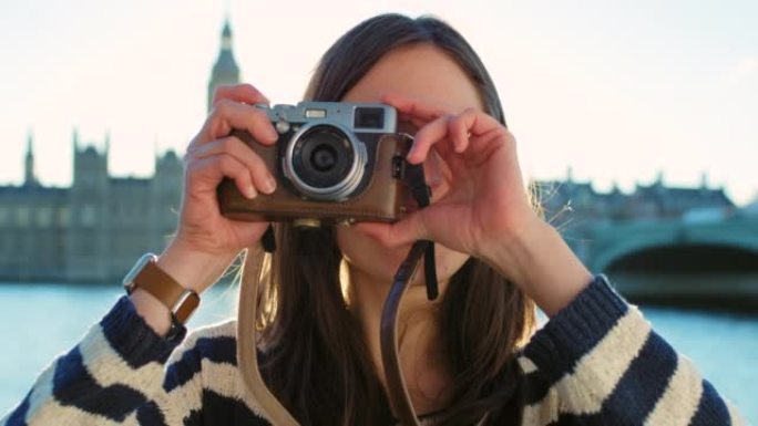 4k视频片段，一名年轻女子在探索城市时用相机拍照
