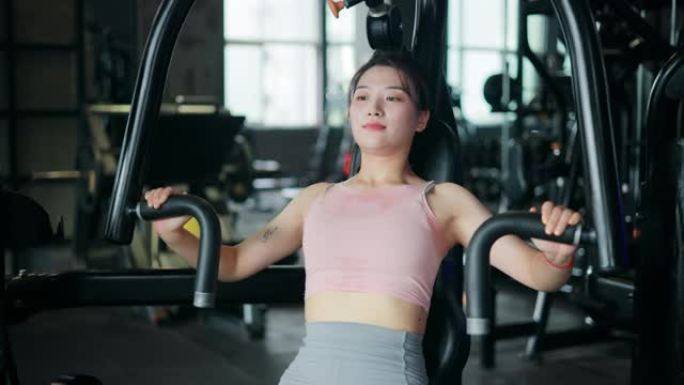 在健身房做胸部锻炼的年轻女性