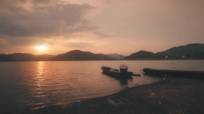 日落时湖中木船的宁静场景