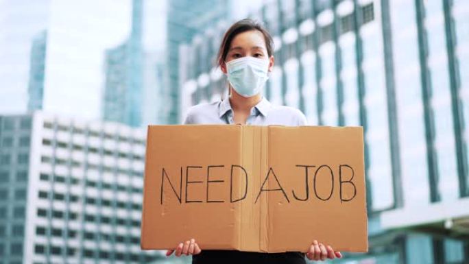 亚洲女性失业，她手上拿着 “需要工作” 的牌子