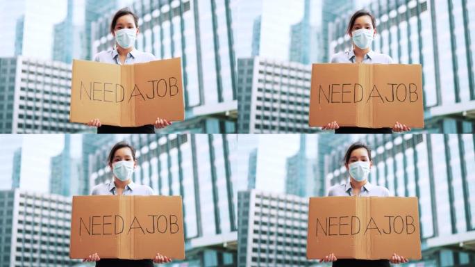 亚洲女性失业，她手上拿着 “需要工作” 的牌子
