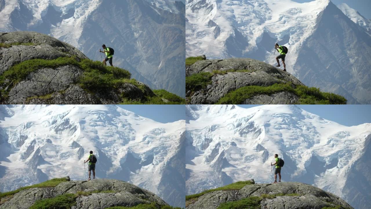 Men hiker climbing to the top of mountain and rais