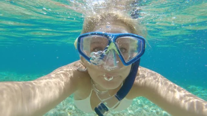 CU年轻女子在阳光明媚的海洋中水下浮潜