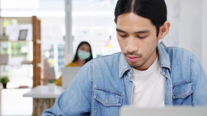 亚洲商人社交距离在新的正常情况下使用笔记本电脑向同事介绍有关在家庭办公室工作时视频通话计划的病毒预防