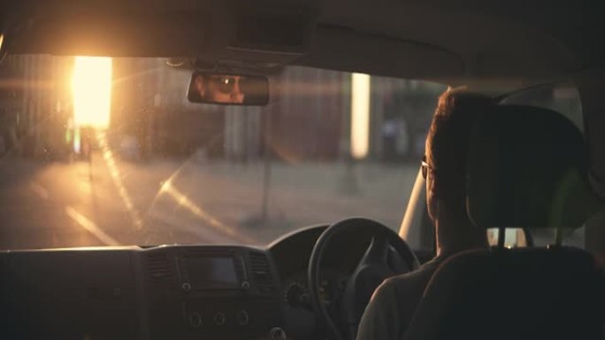 日落背景下的人开车。变形镜头拍摄