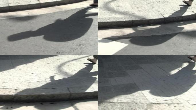 一个男人走在街上的影子。低角度视图。