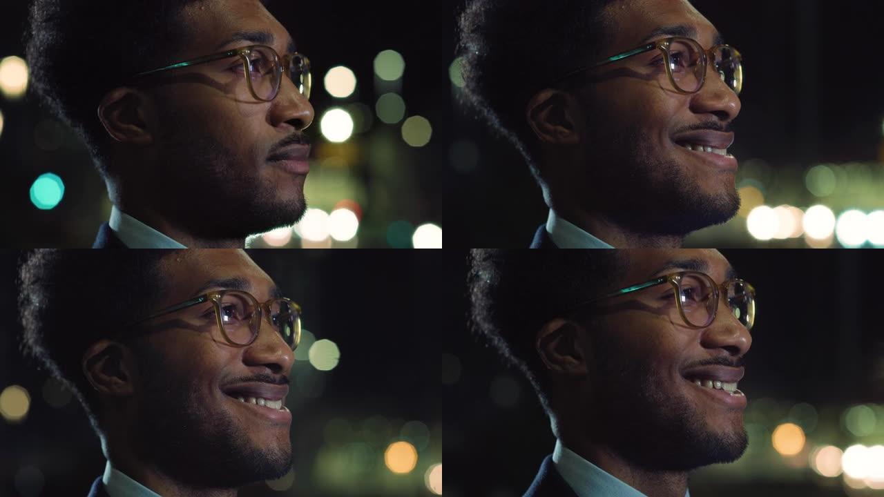 一个英俊时尚的黑人男性晚上站在街上欣赏城市景色的特写镜头。一个穿着西装的非洲裔美国人的肖像，穿着波克