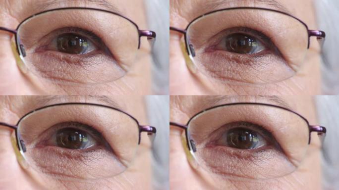 戴眼镜的高级女性眼睛的特写脸，以改善视力。一位戴着眼镜的老年女士的肖像，以帮助视力或近视。随着年龄的