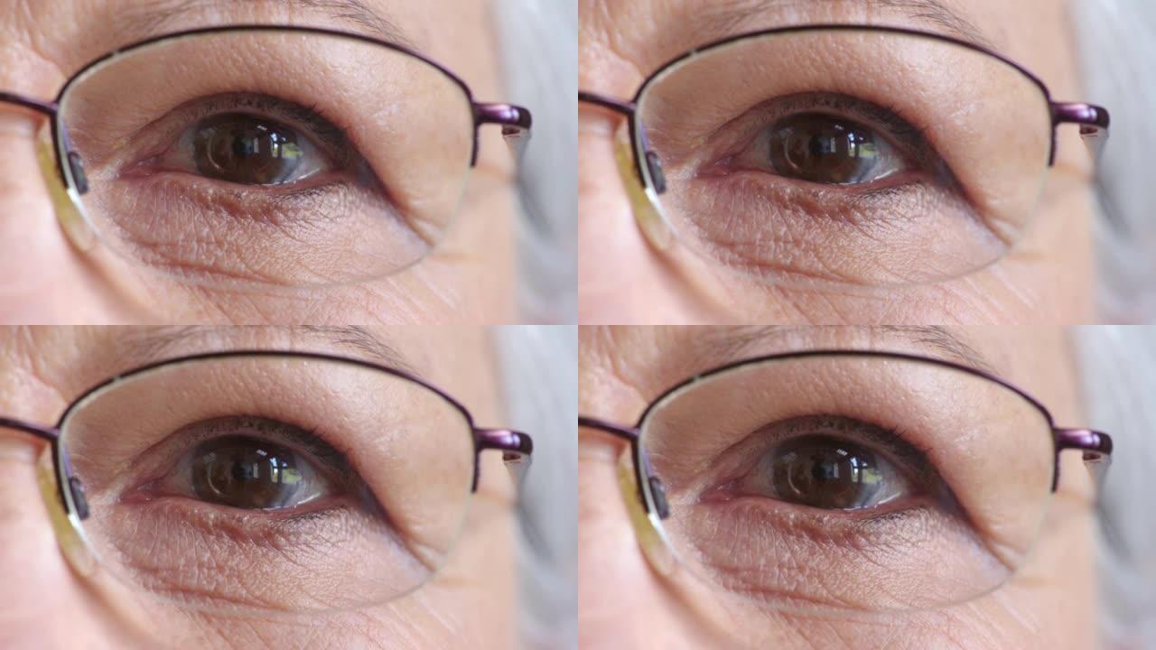 戴眼镜的高级女性眼睛的特写脸，以改善视力。一位戴着眼镜的老年女士的肖像，以帮助视力或近视。随着年龄的
