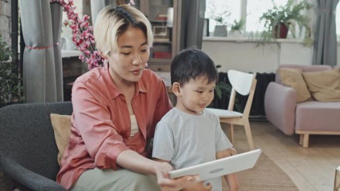 亚洲妈妈和小男孩在家在平板电脑上进行视频聊天