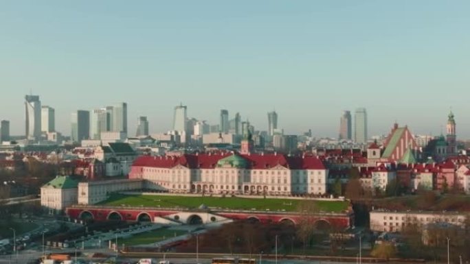 无人机沿着历史悠久的华沙老城区飞行，在蓝色的日出天空下展示现代市中心建筑的天际线。