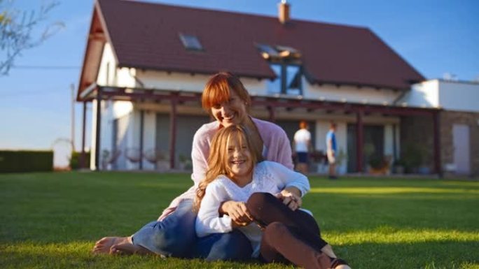 SLO MO慈爱的母亲和她的女儿在绿色的草坪上玩得开心